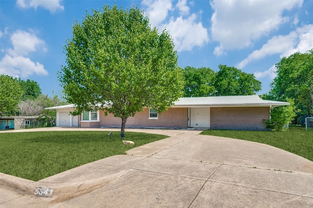 ranch-style house featuring brick siding, driveway, a front yard, and a garage