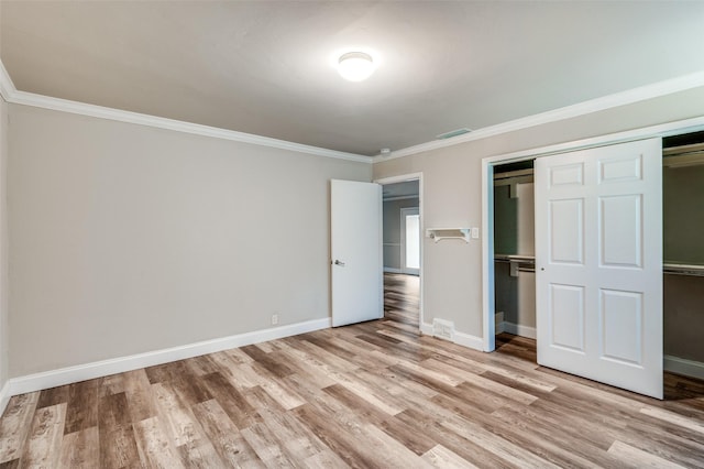 unfurnished bedroom with light wood finished floors, visible vents, a closet, and ornamental molding
