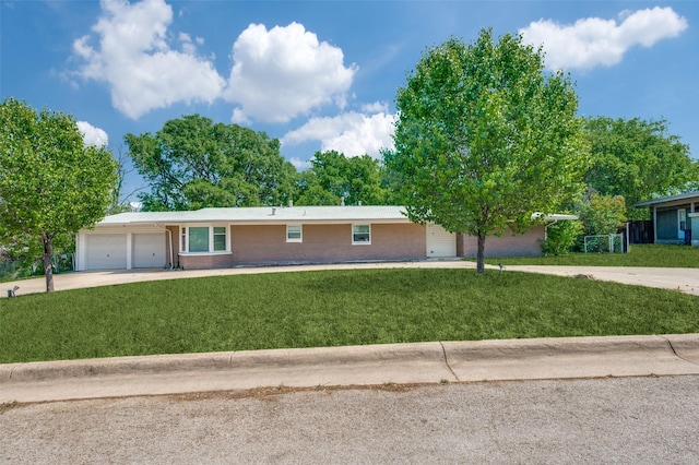 single story home featuring concrete driveway, a front lawn, brick siding, and a garage