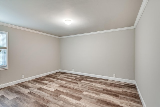empty room featuring wood finished floors, baseboards, and ornamental molding