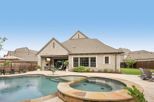 view of swimming pool featuring a fenced backyard, a pool with connected hot tub, and a patio area