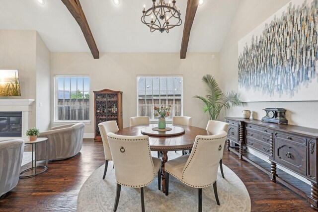 living area featuring an inviting chandelier, beam ceiling, high vaulted ceiling, a glass covered fireplace, and wood finished floors