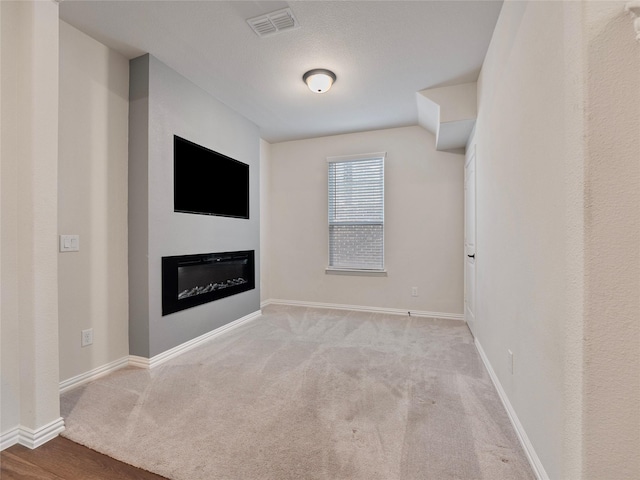 542 Freed Dr, Fate, TX 75087 - unfurnished living room featuring carpet flooring, a glass covered fireplace, and baseboards