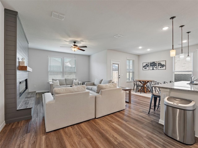 542 Freed Dr, Fate, TX 75087 - living room with a ceiling fan, healthy amount of natural light, dark wood-type flooring, a large fireplace, and recessed lighting