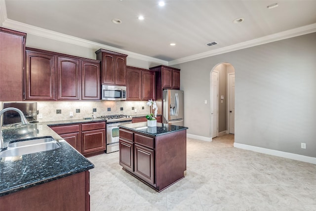4523 W University Blvd, Dallas, TX 75209 - kitchen with stainless steel appliances, arched walkways, a sink, tasteful backsplash, and dark stone countertops
