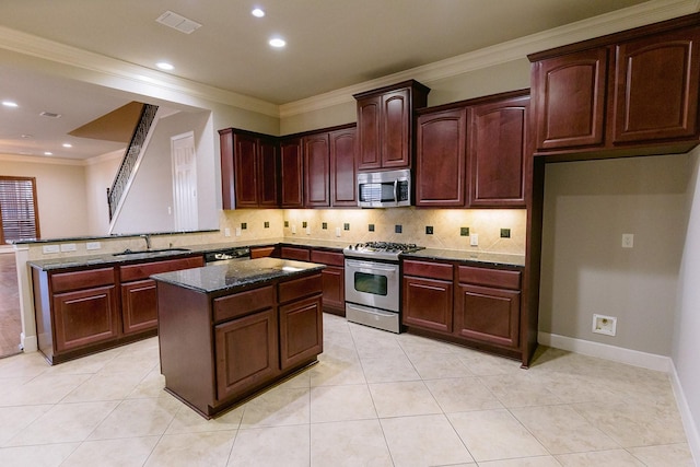 4523 W University Blvd, Dallas, TX 75209 - kitchen with stainless steel appliances, a sink, a kitchen island, dark stone counters, and decorative backsplash