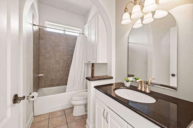 bathroom with tile patterned floors, vanity, an inviting chandelier, toilet, and shower / bath combo with shower curtain