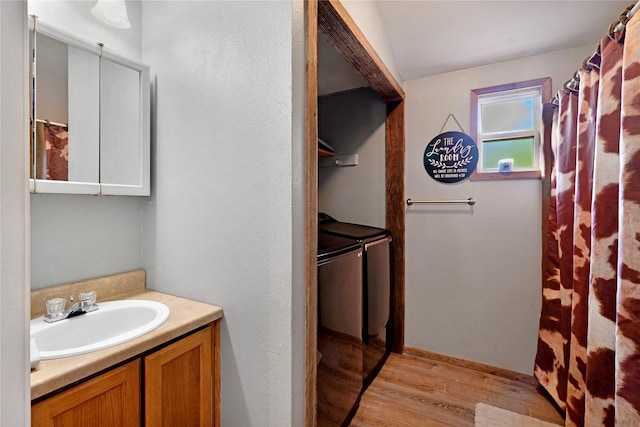 28 Private Road 45075, Powderly, TX 75473 - bathroom featuring wood finished floors, washer and clothes dryer, and vanity