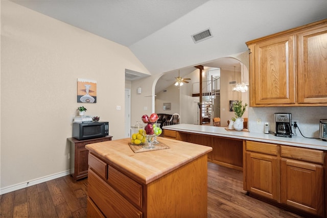kitchen featuring arched walkways, visible vents, ceiling fan, black microwave, and wooden counters