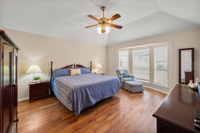 bedroom with vaulted ceiling, baseboards, a ceiling fan, and wood-type flooring