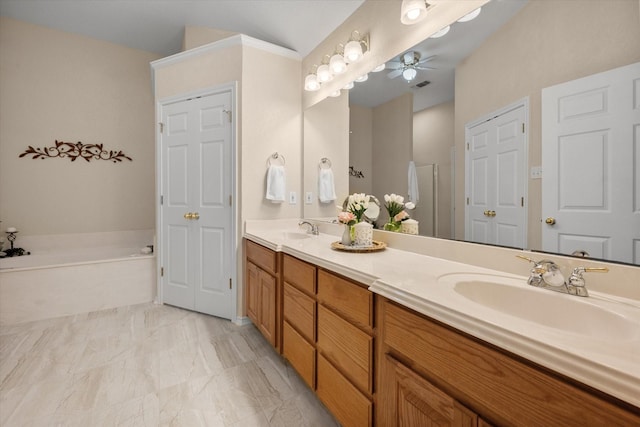 full bath with double vanity, a garden tub, a ceiling fan, and a sink