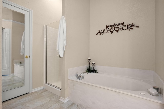 bathroom featuring a bath and a stall shower