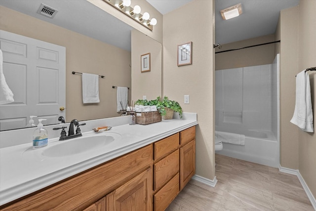 bathroom with visible vents, toilet, vanity, baseboards, and bathtub / shower combination