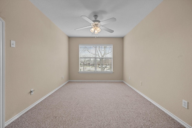 spare room with ceiling fan, light carpet, and baseboards
