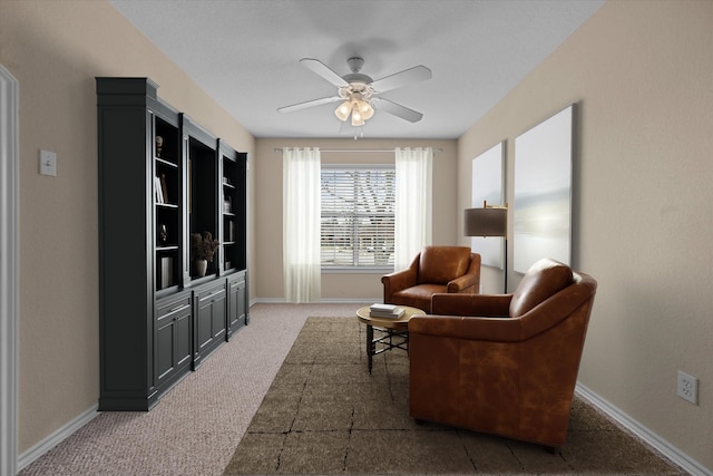 sitting room featuring carpet, a ceiling fan, and baseboards