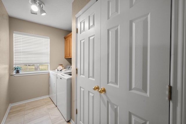 washroom with washing machine and clothes dryer, baseboards, marble finish floor, and cabinet space