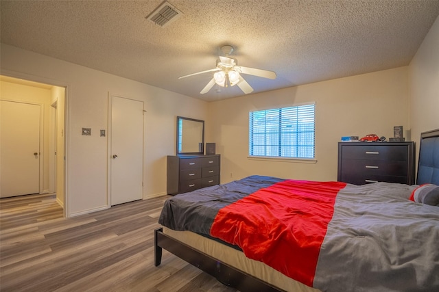 1234 Royal Oak Dr, Desoto, TX 75115 - bedroom featuring wood finished floors, visible vents, a textured ceiling, and ceiling fan