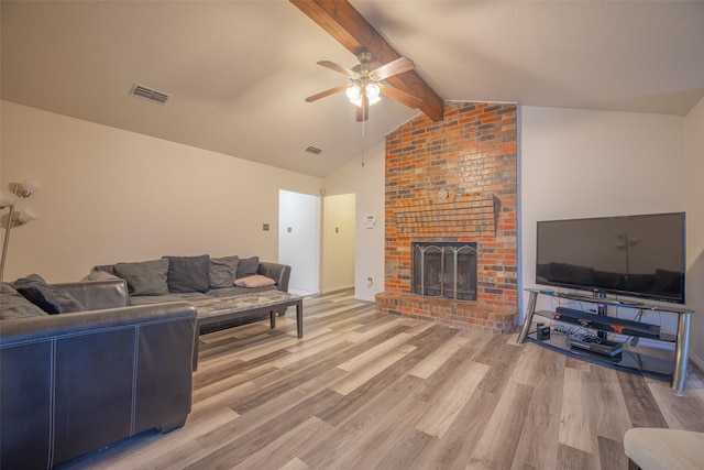1234 Royal Oak Dr, Desoto, TX 75115 - living room with lofted ceiling with beams, light wood-style flooring, visible vents, a ceiling fan, and a brick fireplace