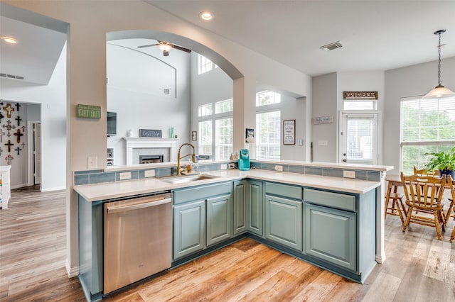 kitchen featuring arched walkways, dishwasher, visible vents, and a sink