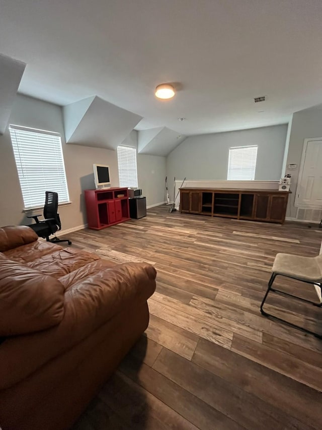 additional living space featuring lofted ceiling, wood finished floors, visible vents, and a wealth of natural light