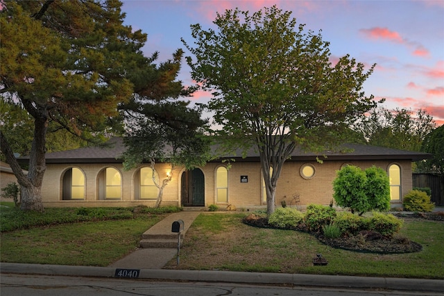 ranch-style house with a front lawn and brick siding