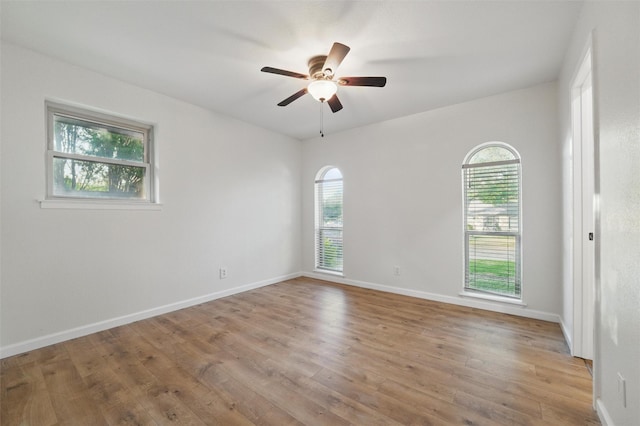 empty room with baseboards, a ceiling fan, and wood finished floors