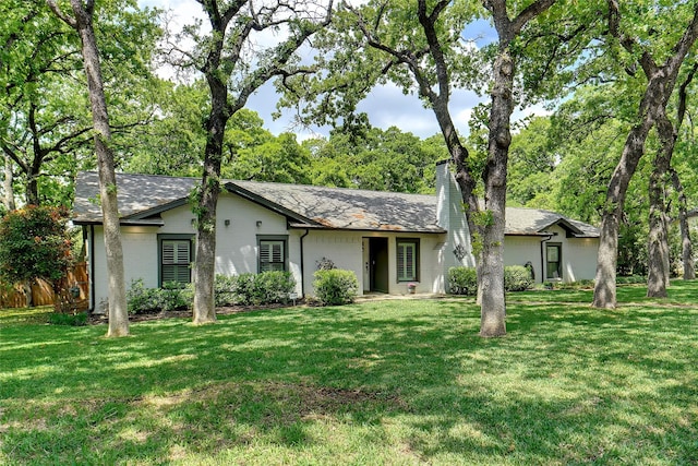 view of front of property with a chimney, fence, and a front yard