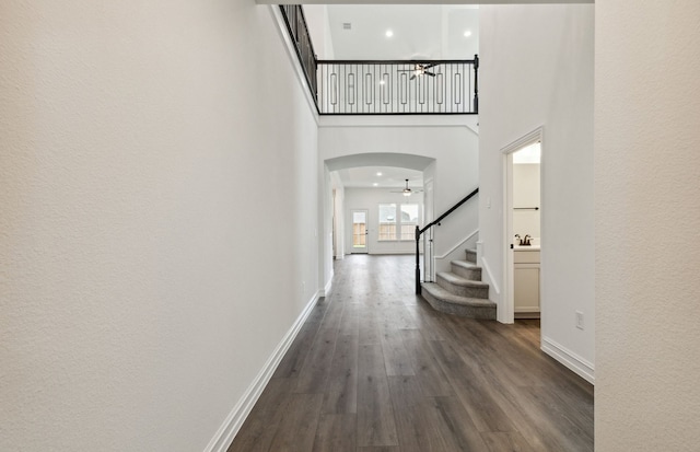 1624 Cottonwood Valley Dr, Celina, TX 75009 - hall with stairway, a high ceiling, arched walkways, baseboards, and dark wood-style flooring