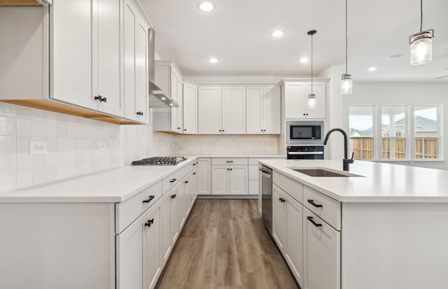 1624 Cottonwood Valley Dr, Celina, TX 75009 - kitchen with appliances with stainless steel finishes, open floor plan, arched walkways, a sink, and light wood finished floors