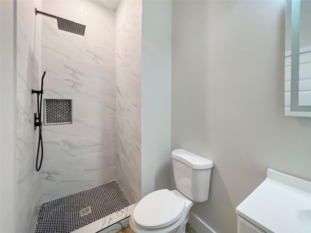 bathroom featuring toilet, vanity, and a marble finish shower