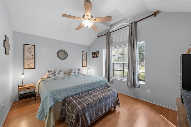 bedroom featuring lofted ceiling, baseboards, a ceiling fan, and wood finished floors