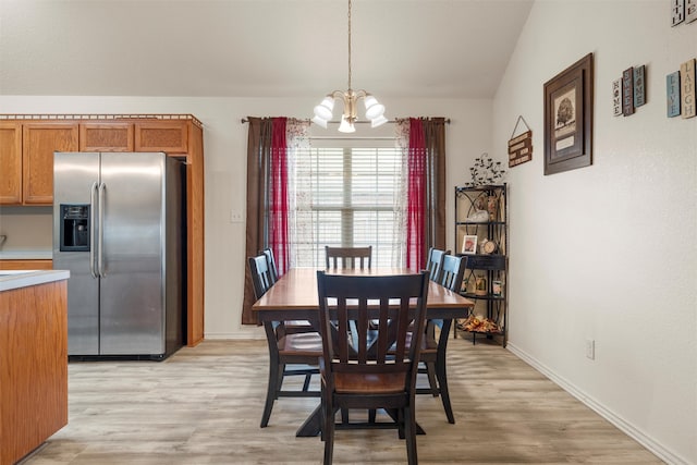 dining room featuring light wood-type flooring, baseboards, and an inviting chandelier