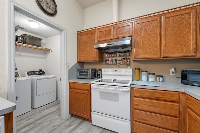 kitchen with white electric range, separate washer and dryer, light wood-style floors, light countertops, and under cabinet range hood