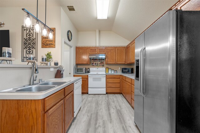 kitchen featuring vaulted ceiling, a sink, white appliances, under cabinet range hood, and visible vents