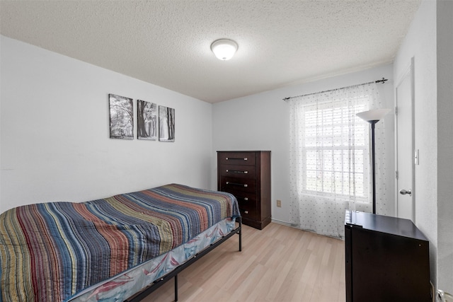 bedroom featuring wood finished floors and a textured ceiling