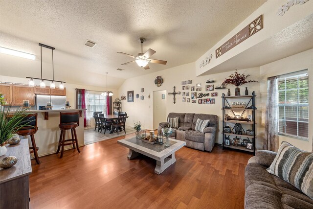 living area featuring plenty of natural light, wood finished floors, a textured ceiling, and ceiling fan
