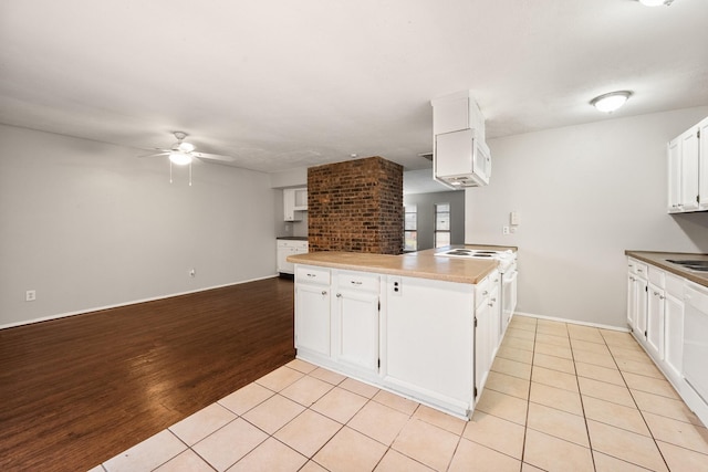 6606 Greenfield Dr, Arlington, TX 76016 - kitchen with white range with electric cooktop, light tile patterned flooring, ceiling fan, a peninsula, and white cabinetry