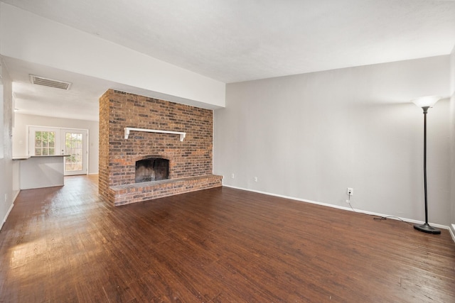6606 Greenfield Dr, Arlington, TX 76016 - unfurnished living room featuring baseboards, wood finished floors, visible vents, and a brick fireplace