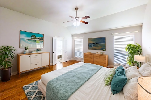 bedroom featuring lofted ceiling, baseboards, a ceiling fan, and wood finished floors