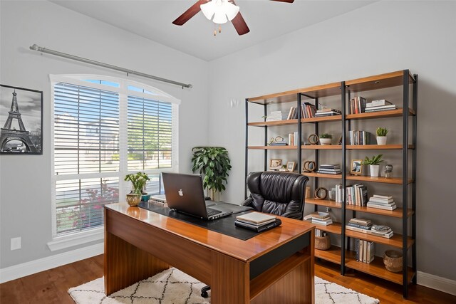 home office featuring baseboards, a ceiling fan, and wood finished floors