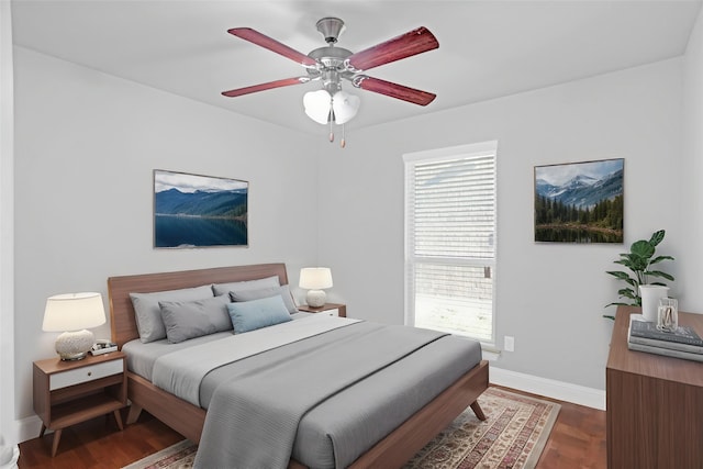 bedroom featuring baseboards, dark wood-style flooring, and a ceiling fan