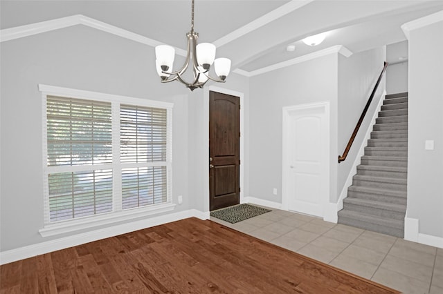 entryway featuring stairs, wood finished floors, ornamental molding, a chandelier, and baseboards