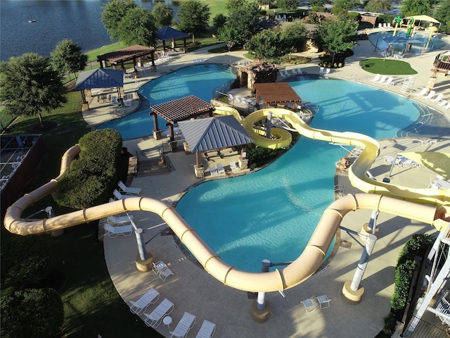 community pool featuring a water play area, a gazebo, a patio area, and a water slide