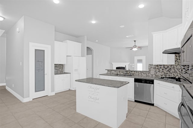 kitchen with a sink, stainless steel appliances, arched walkways, ceiling fan, and tasteful backsplash