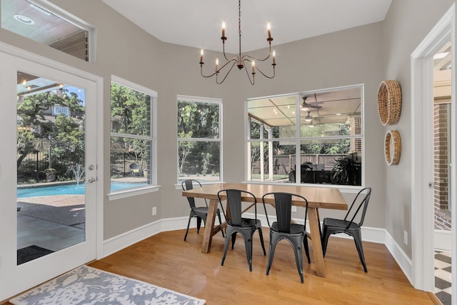 dining room featuring baseboards, wood finished floors, and a chandelier