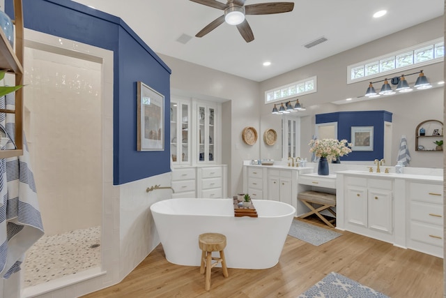 full bathroom with walk in shower, visible vents, a ceiling fan, and wood finished floors