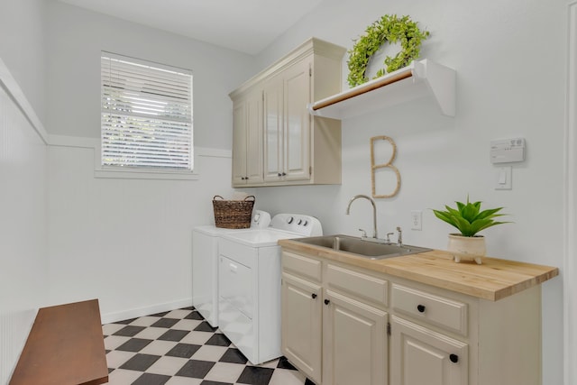 laundry room with washing machine and clothes dryer, dark floors, a sink, and cabinet space