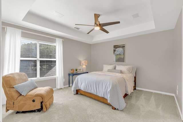 bedroom featuring baseboards, carpet flooring, and a raised ceiling