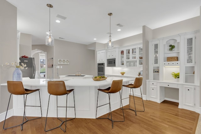 kitchen featuring appliances with stainless steel finishes, a sink, white cabinetry, and light wood-style flooring