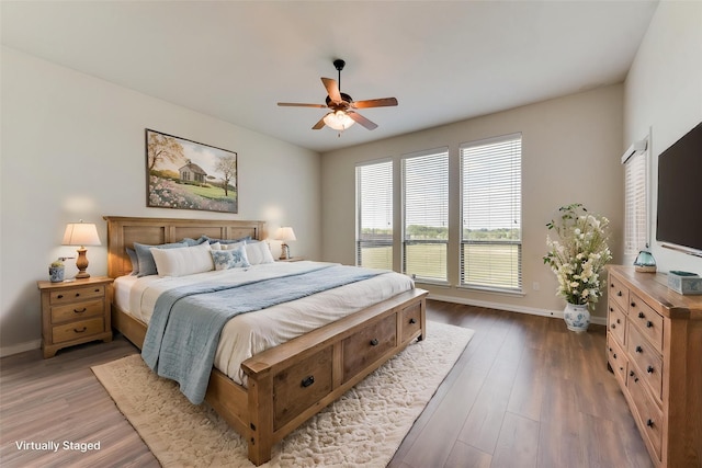 bedroom featuring ceiling fan, baseboards, and wood finished floors